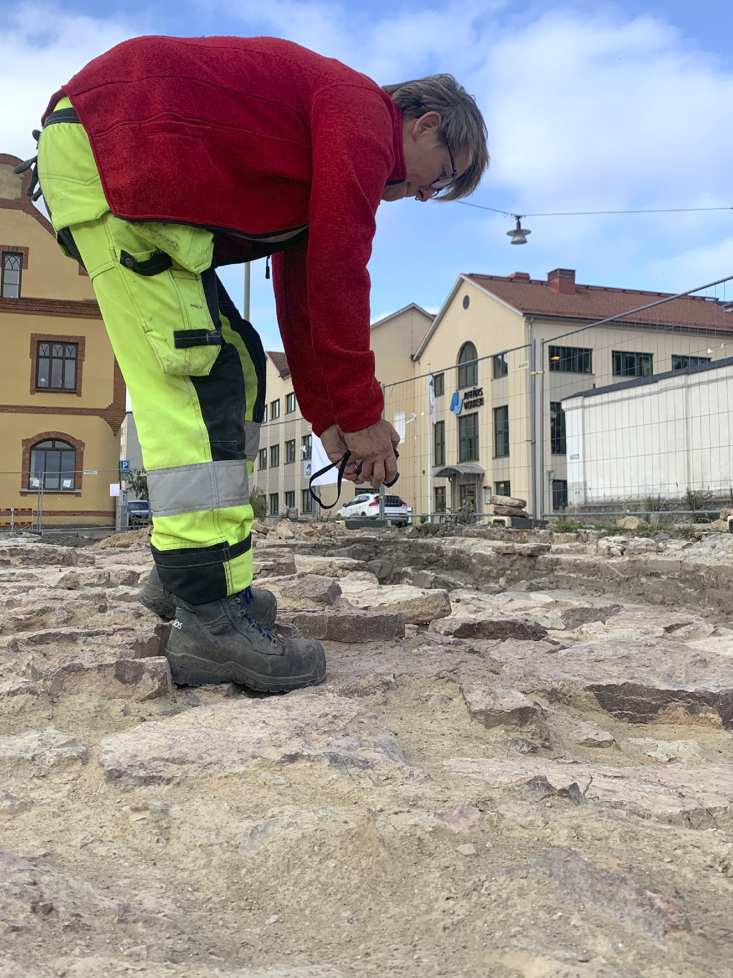 Arkeologen Pia Svensson fotograferar ugnen för att kunna bygga upp en 3D modell. 