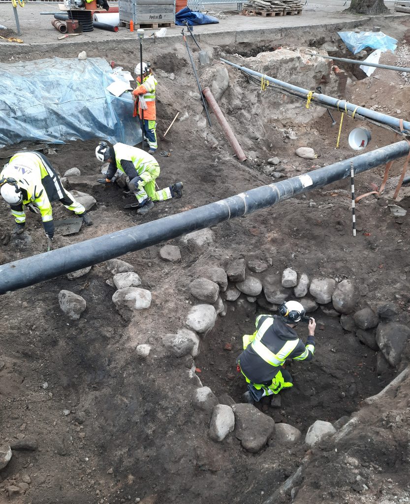 Arkeologer gräver ut en brunn.