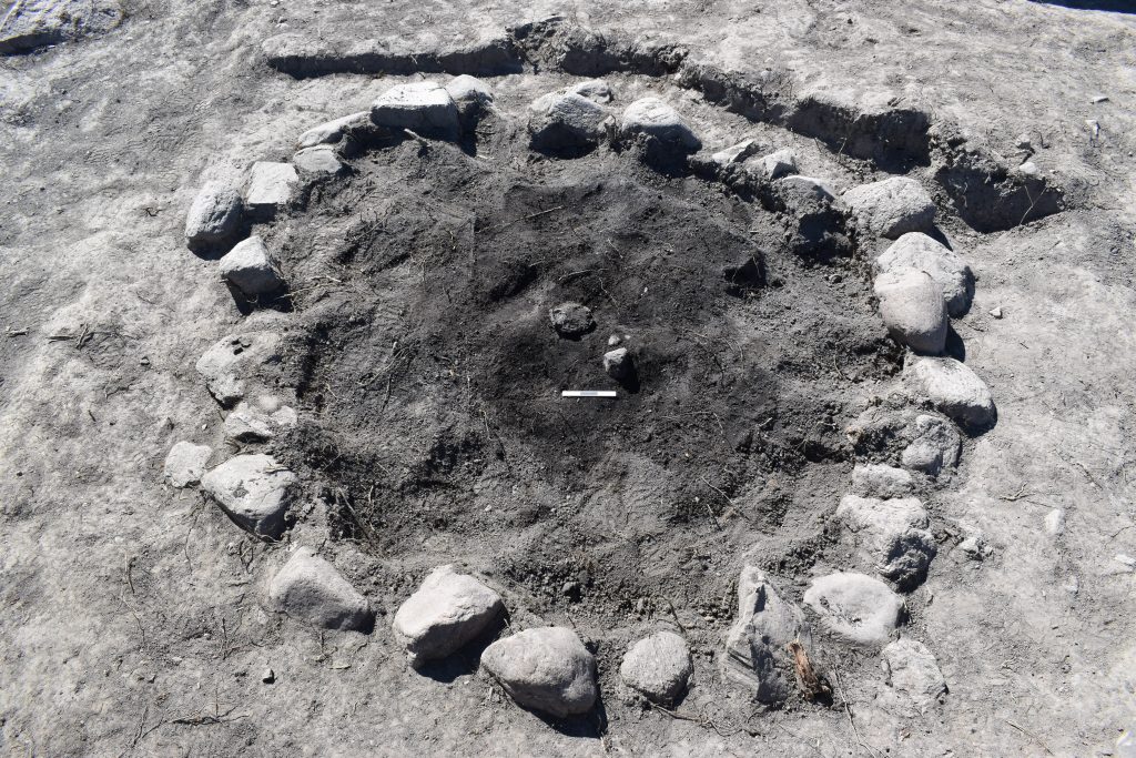 Under stenarna fanns kremerade rester från brandbålet, med bland annat brända ben. I mitten syns även ett fragmentariskt keramikkärl. 