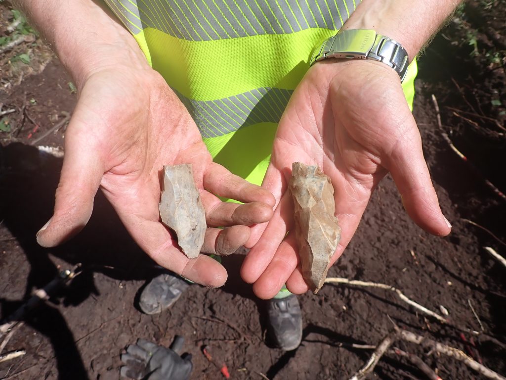 En kärnyxa (till höger) och en del av en spånkärna, är några av de flint artefakter som återfanns i samband med undersökningen.