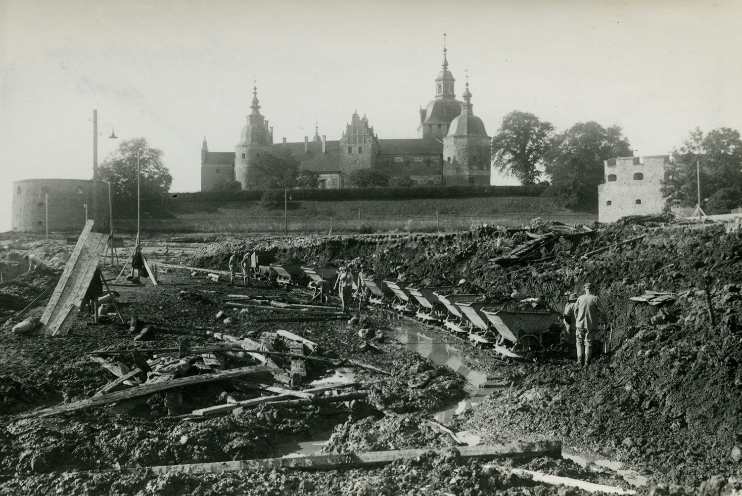 Fotot är tagit år 1933 i Slottsfjärden och visar den lila järnvägen som byggdes för att transportera bort massorna. Fotograf A. E. Thulin. Kalmar läns museum. (KLMF.Fjärden00011).