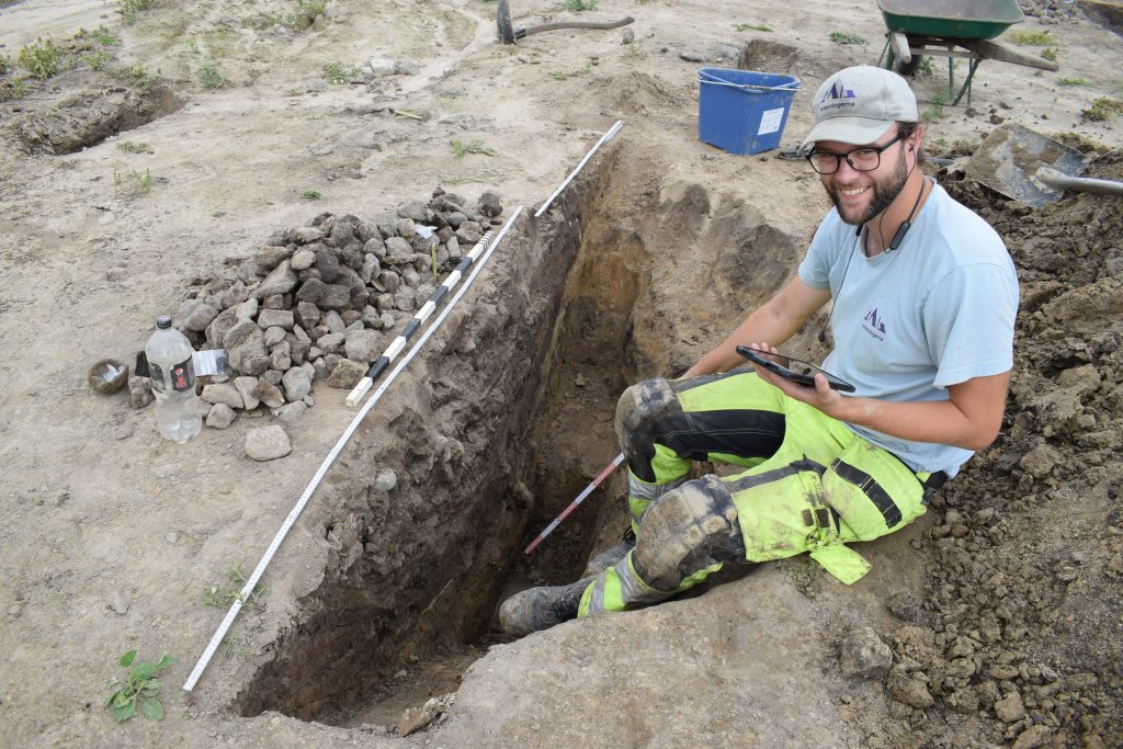 Arkeolog som sitter i en grop